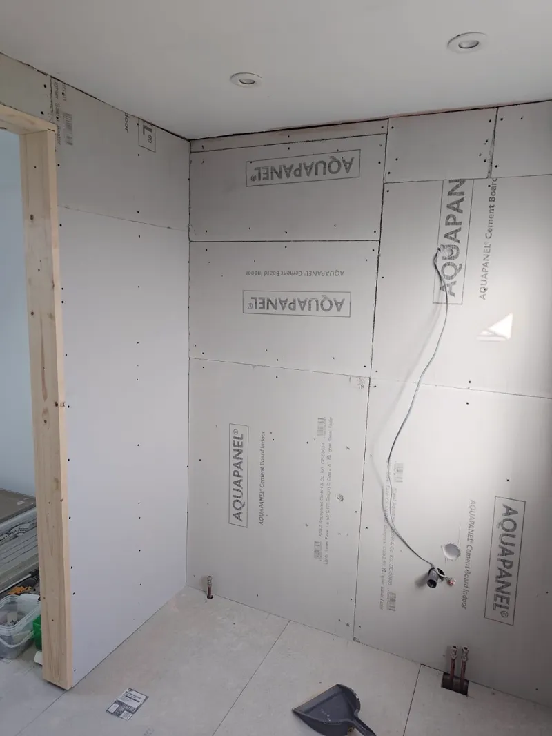 Waterproof tanking membrane laid over cement backer board on a shower floor.