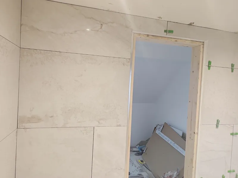 Completed bathroom with a white curved shower enclosure and grey floor tiles.