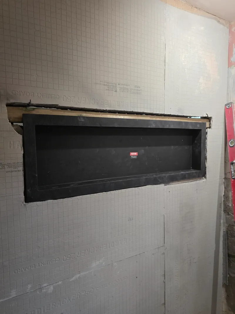 A recessed storage niche built into a shower wall, waterproof lining fitted.